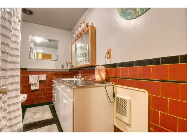 a bedroom with a large bed and a flat tv screen on dresser