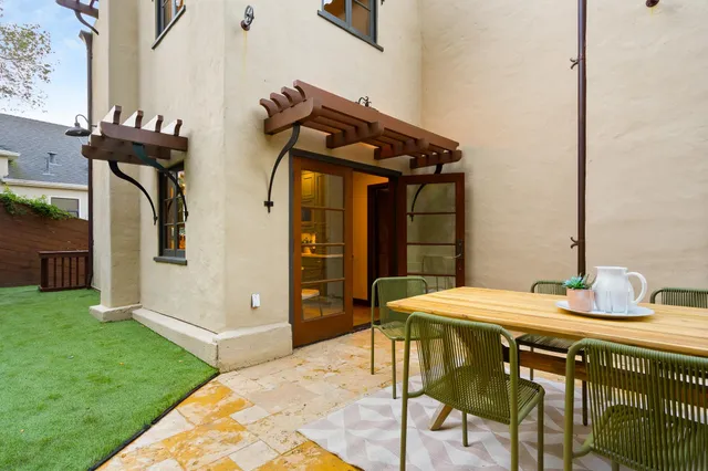 a view of a patio with table and chairs with wooden floor and fence