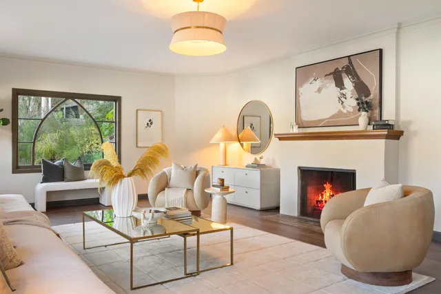a living room with furniture a large window and a fireplace