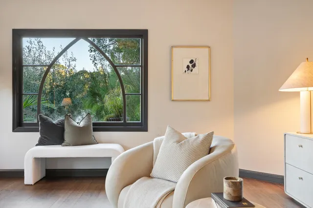 a view of a room with a large window and sitting area