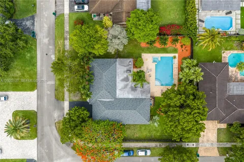 a view of a house with a big yard and large trees