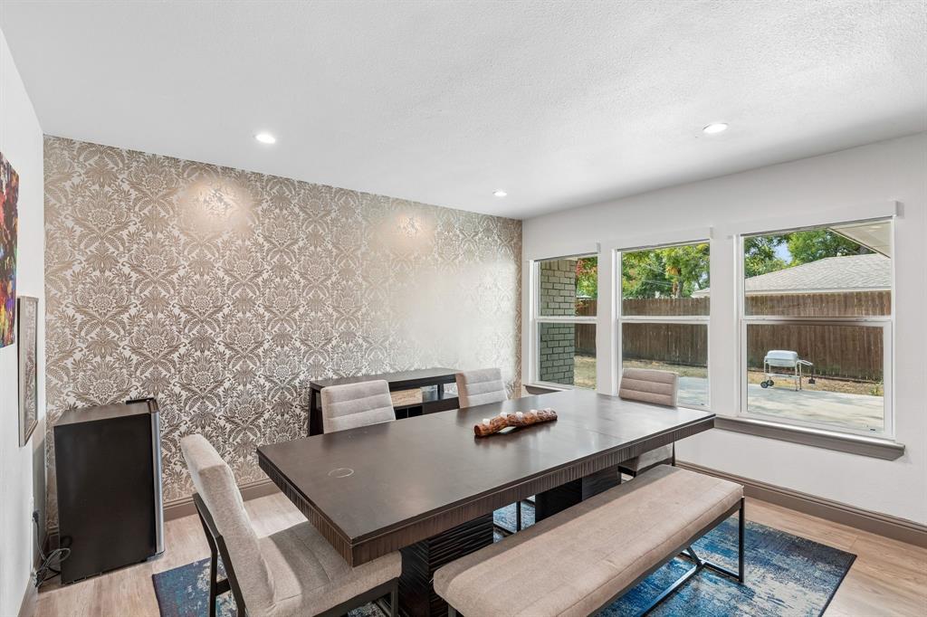 5216 Ashbrook Road Dallas, TX 75227 - Photo 4 of 28 Recessed ceiling lighting, patterned accent wall, multiple windows, wood-finish flooring, and a built-in buffet cabinet