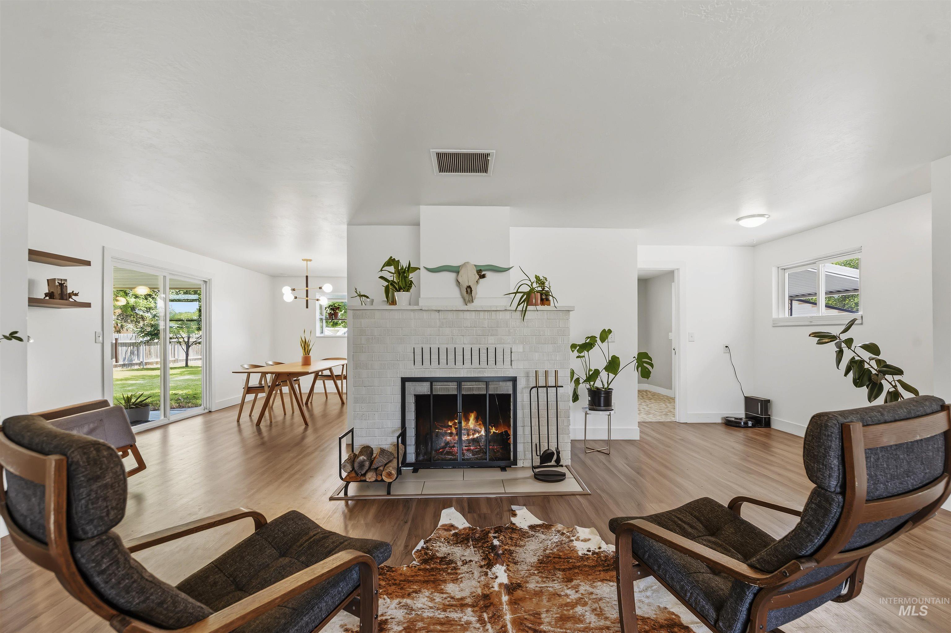 355 East Beacon Light Road Eagle, ID 83616 - Photo 8 of 47 Living space featuring a tiled fireplace with hearth, wood-finish flooring, and recessed lighting