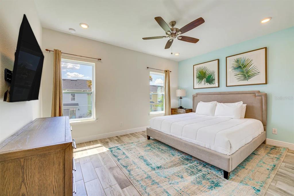 8209 Surf Street Kissimmee, FL 34747 - Photo 14 of 74 a bedroom with a large bed a flat tv screen and a dresser