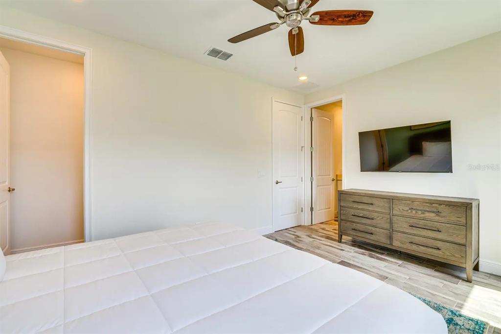 8209 Surf Street Kissimmee, FL 34747 - Photo 15 of 74 a bedroom with a bed and a flat screen tv