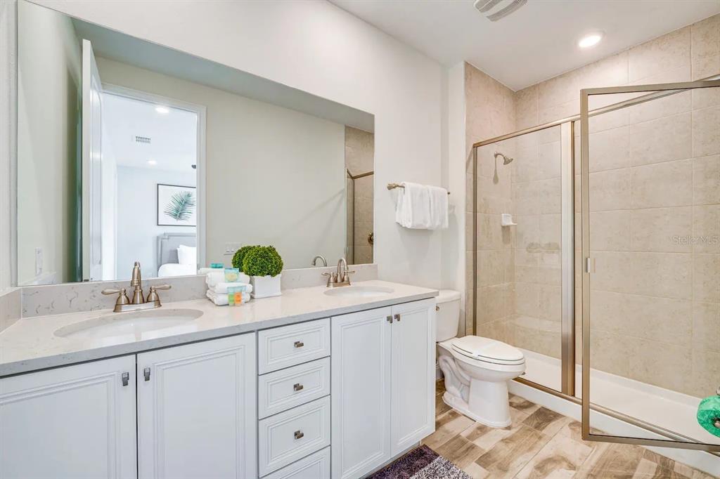 8209 Surf Street Kissimmee, FL 34747 - Photo 18 of 74 a bathroom with a double vanity sink toilet and shower