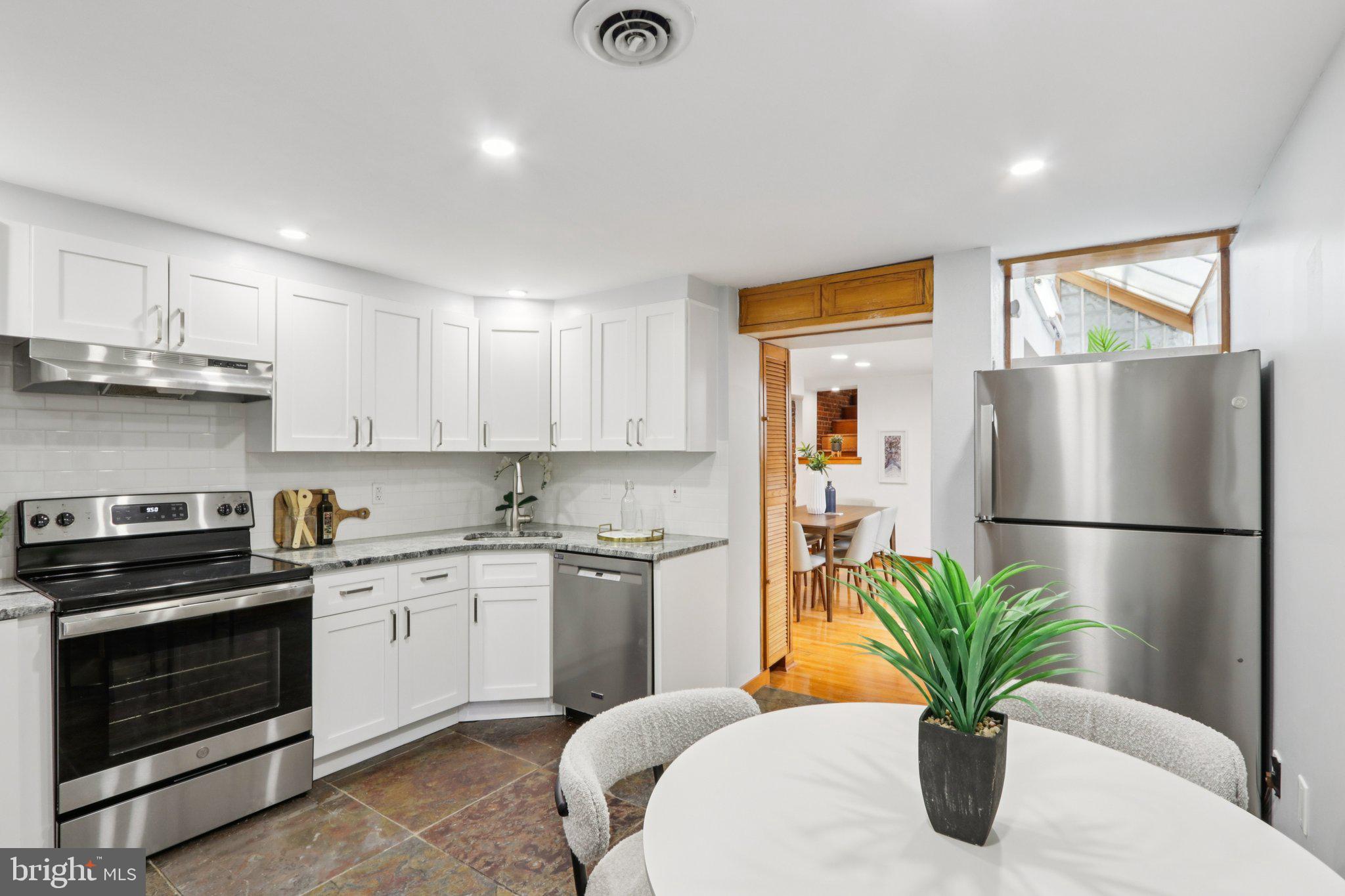 764 South Front Street Philadelphia, PA 19147 - Photo 12 of 46 a kitchen with stainless steel appliances a white refrigerator a sink a stove a dining table and chairs