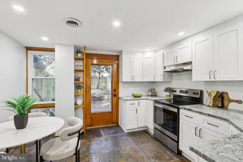 a kitchen with stainless steel appliances granite countertop a stove a sink dishwasher and a refrigerator with wooden floor