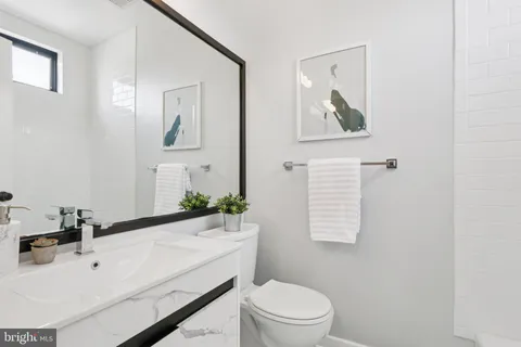 a bathroom with a sink a toilet and mirror