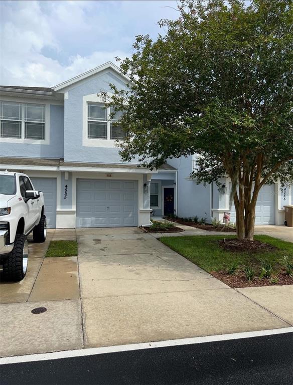 a view of a white house with a large tree