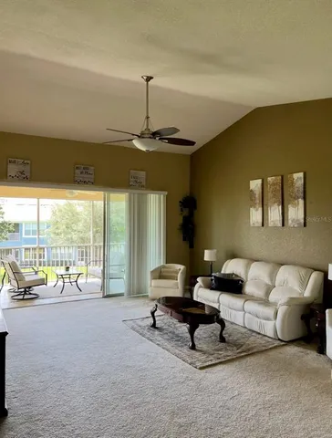 a living room with furniture and floor to ceiling window