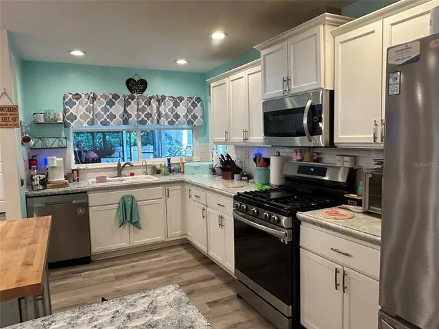 a kitchen with a sink stove and microwave