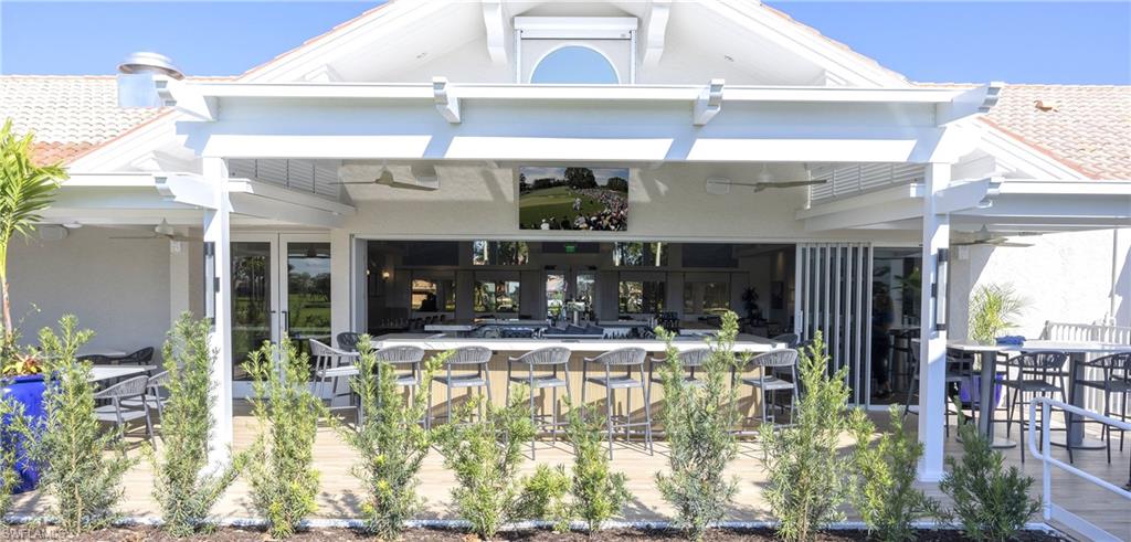 11745 Quail Village Way Naples, FL 34119 - Photo 20 of 24 Back of house featuring a bar, ceiling fan, stucco siding, and a tiled roof
