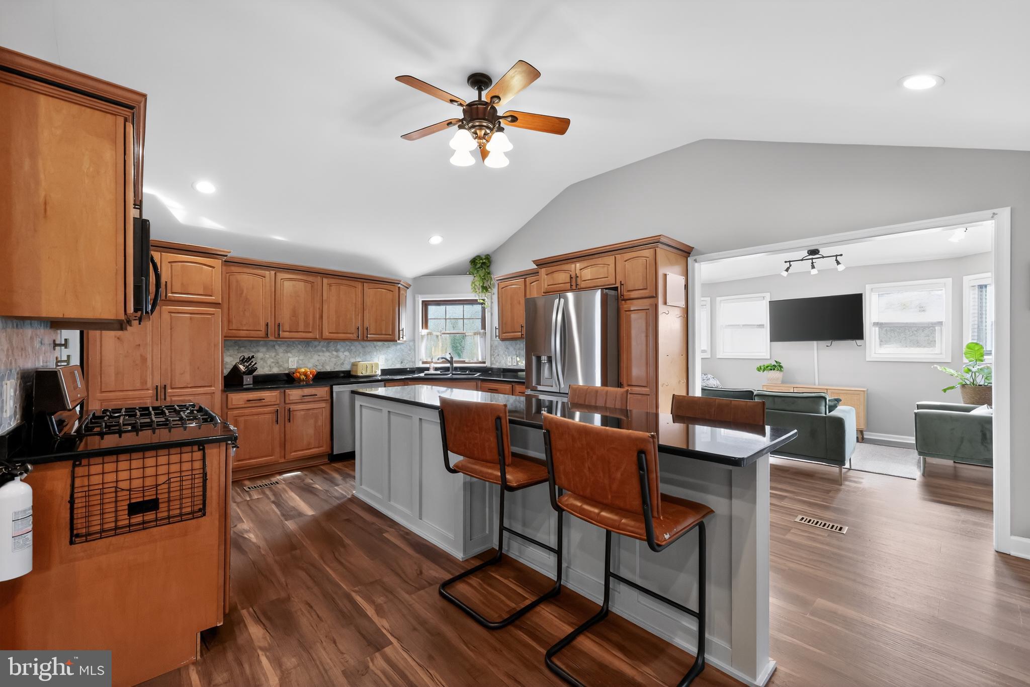 208 Richey Avenue Collingswood, NJ 08107 - Photo 14 of 35 a kitchen with stainless steel appliances kitchen island granite countertop a stove top oven a sink a dining table and chairs with wooden floor