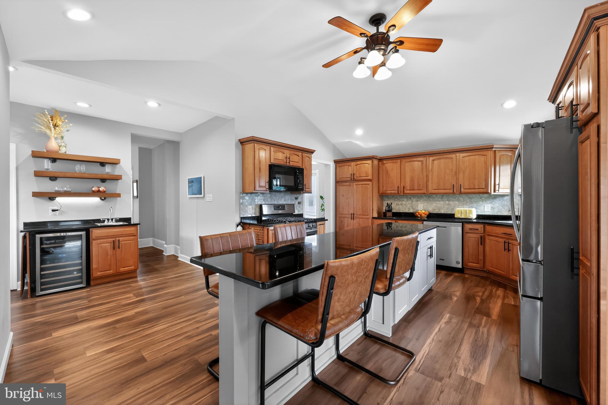 208 Richey Avenue Collingswood, NJ 08107 - Photo 15 of 35 a kitchen with stainless steel appliances kitchen island granite countertop a stove top oven a sink a dining table and chairs with wooden floor
