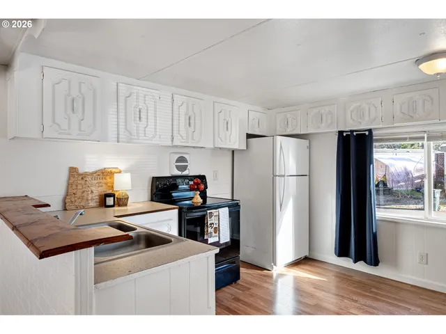 a kitchen with stainless steel appliances kitchen island a refrigerator sink and cabinets