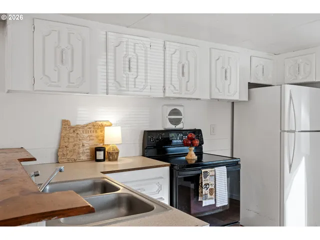 a kitchen with stainless steel appliances granite countertop a refrigerator sink and white cabinets