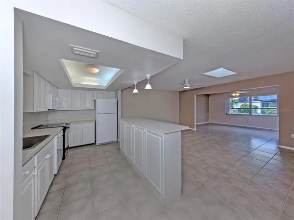 a kitchen with kitchen island white cabinets and stainless steel appliances