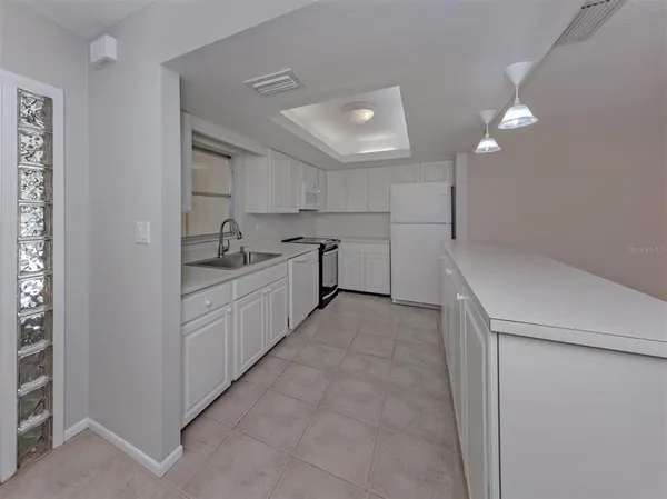 a kitchen with white cabinets and sink