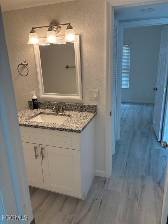 16881 Davis Road, Unit 414 Fort Myers, FL 33908 - Photo 13 of 24 a bathroom with a granite countertop sink a mirror and vanity