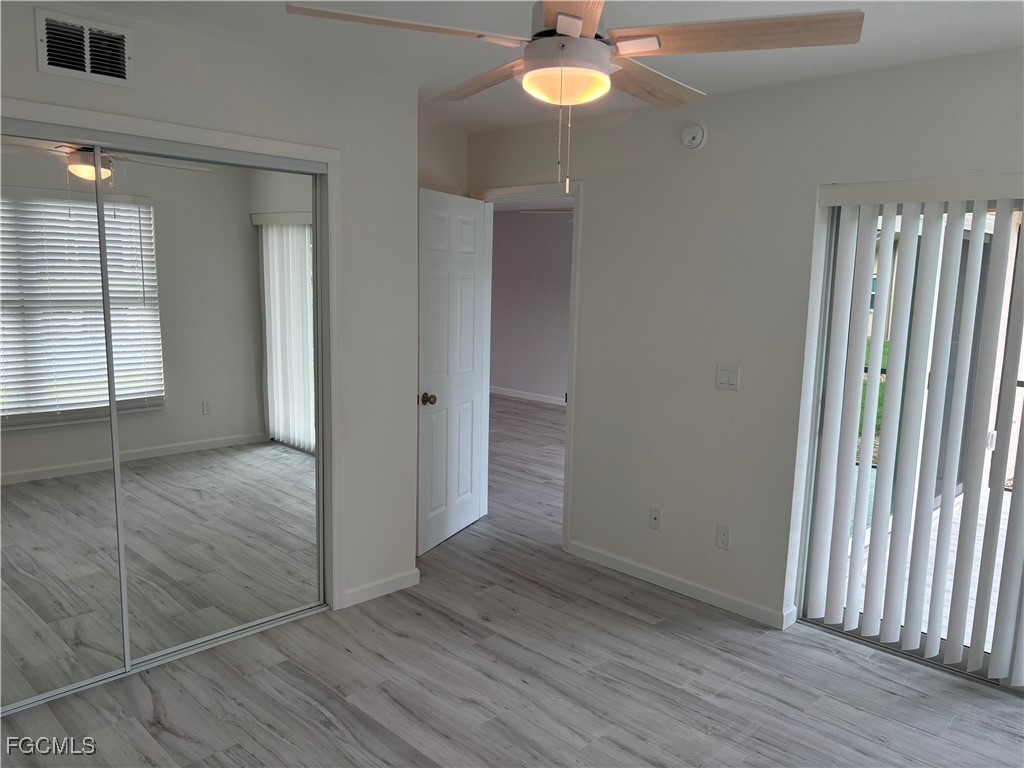 16881 Davis Road, Unit 414 Fort Myers, FL 33908 - Photo 9 of 24 an empty room with wooden floor and way to kitchen