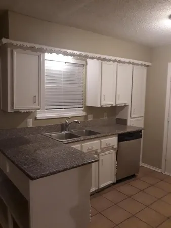 a kitchen with granite countertop sink cabinets and window