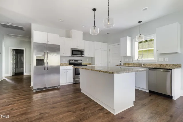 a view of a kitchen with a sink stainless steel appliances and cabinets
