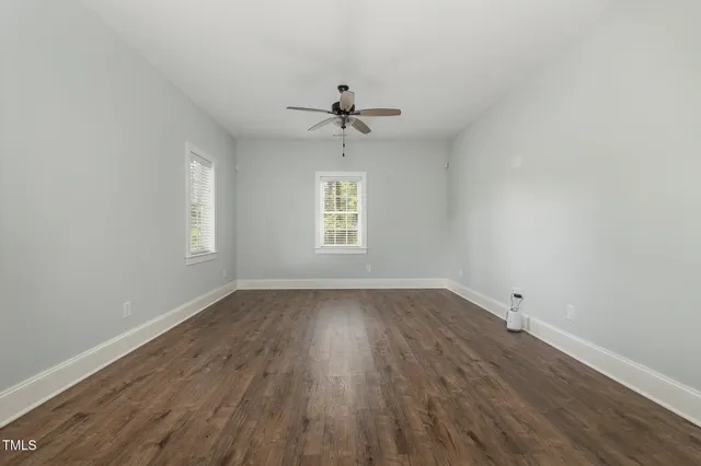 a kitchen with stainless steel appliances granite countertop a stove a sink a refrigerator and white cabinets with wooden floor