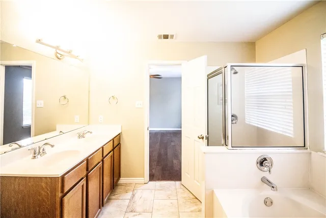 a bathroom with a tub sink and mirror