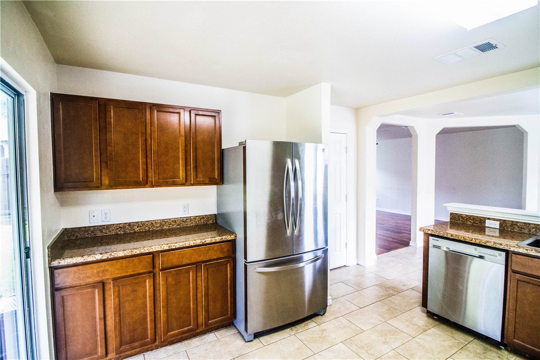 413 Moorhen Cove Leander, TX 78641 - Photo 5 of 18 a kitchen with granite countertop a refrigerator and a stove top oven
