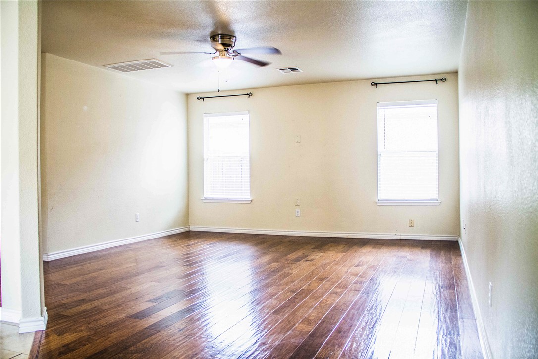 413 Moorhen Cove Leander, TX 78641 - Photo 7 of 18 a view of an empty room with wooden floor and a window