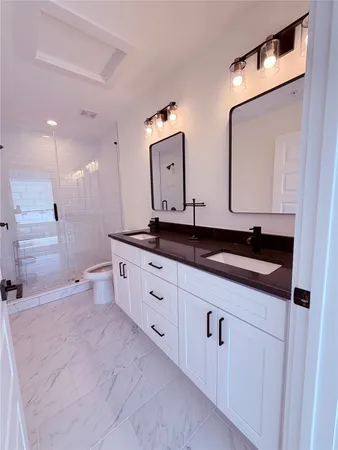 a spacious bathroom with double sink and a mirror