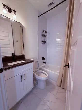a bathroom with a bathtub sink mirror vanity and toilet