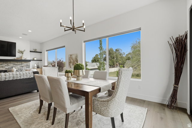 653 East Vandalay Lane Draper, UT 84020 - Photo 15 of 61 Dining area featuring a modern chandelier, wood-finish flooring, and large windows