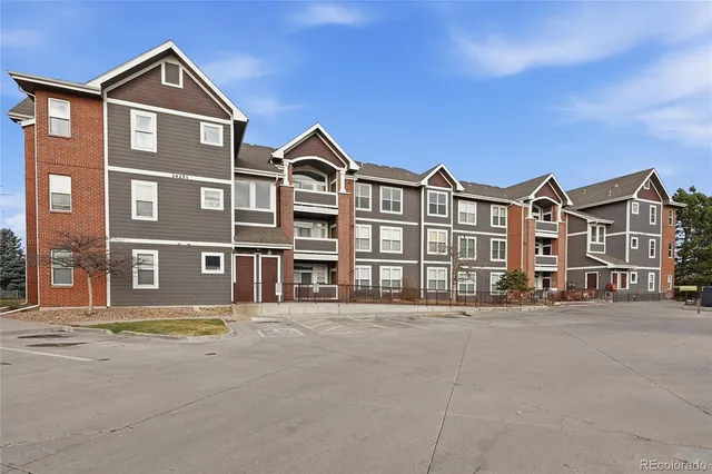 a front view of a residential apartment building with a yard