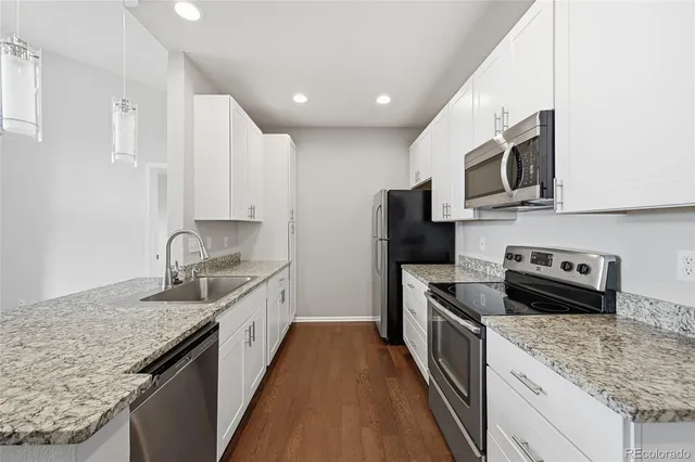 a kitchen with stainless steel appliances granite countertop a sink and stove top oven