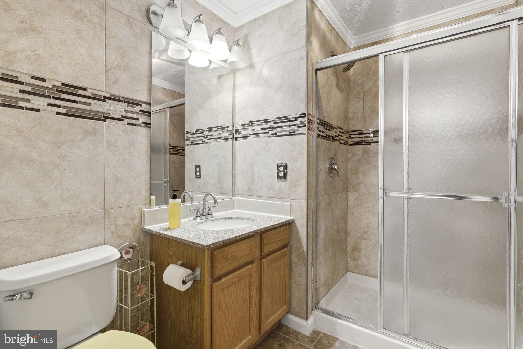 3413 Barkley Woods Road Baltimore, MD 21244 - Photo 18 of 31 a bathroom with a sink a mirror a toilet and shower
