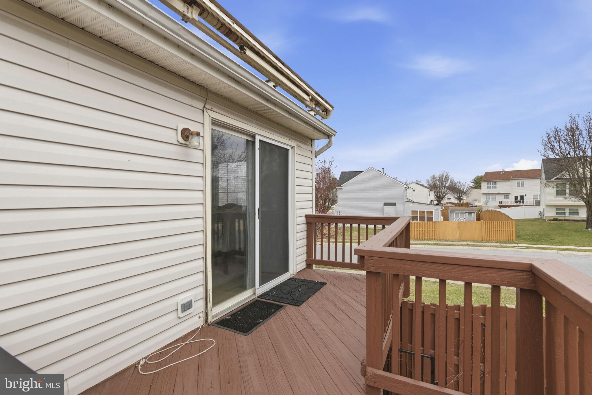 3413 Barkley Woods Road Baltimore, MD 21244 - Photo 20 of 31 a view of a balcony with wooden floor and fence and a floor to ceiling window