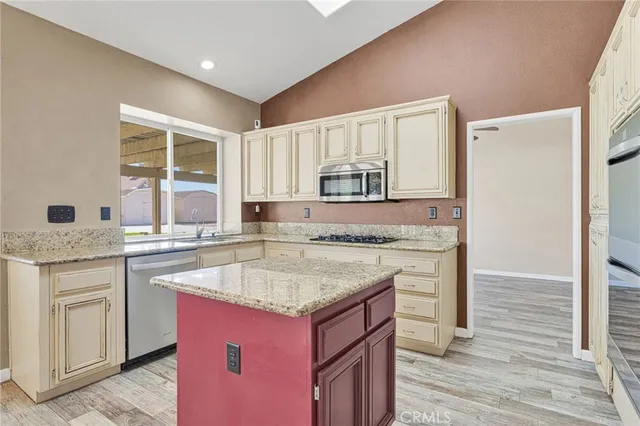a kitchen with granite countertop a sink stove and cabinets