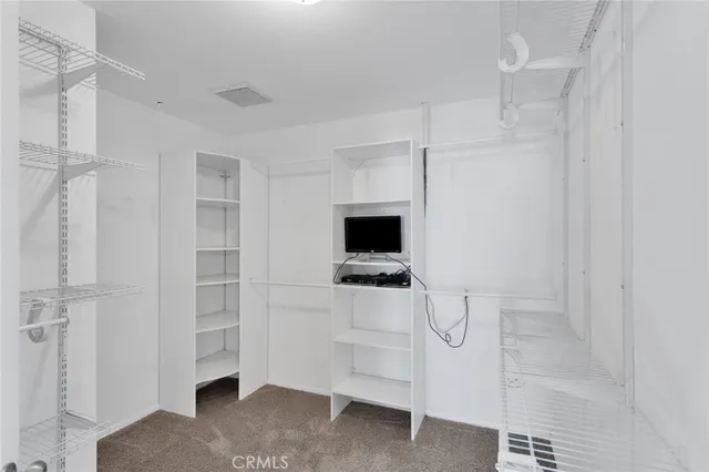 a room with a flat screen tv and white walls