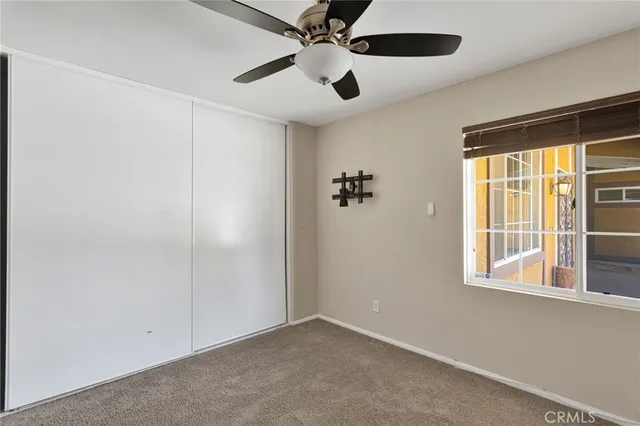 an empty room with windows and fan
