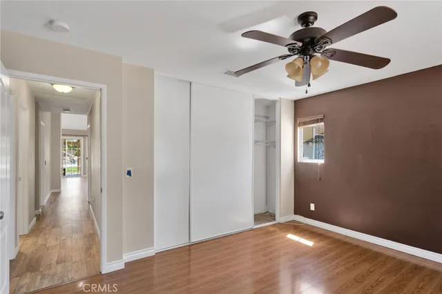 a view of a livingroom with a ceiling fan wooden floor and a ceiling fan