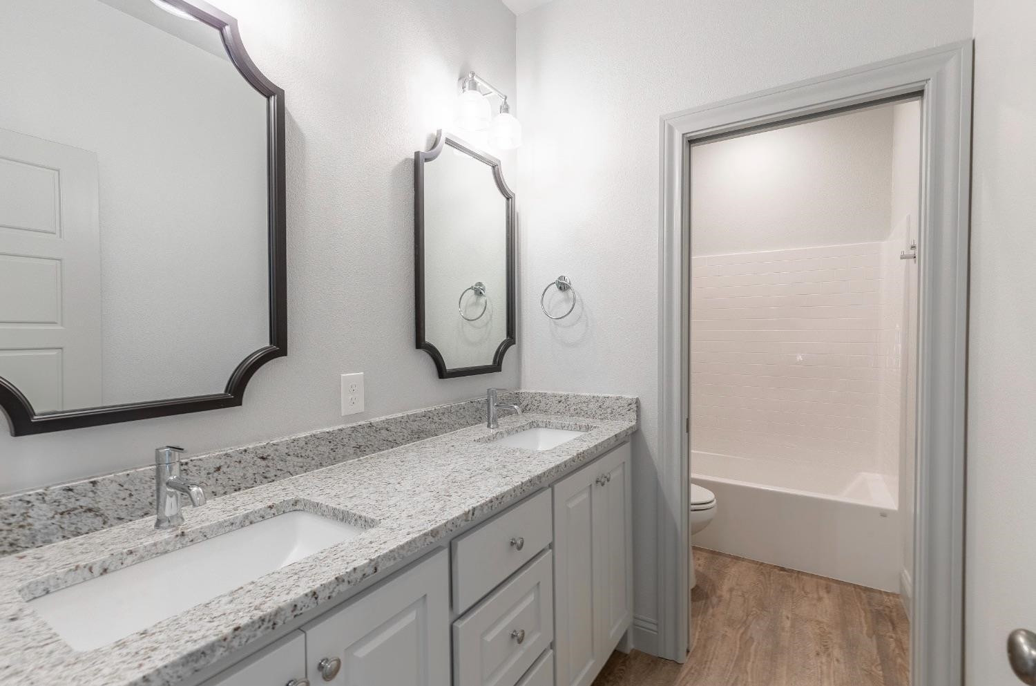 2726 138th Street Lubbock, TX 79423 - Photo 14 of 18 a bathroom with a granite countertop sink a mirror and shower