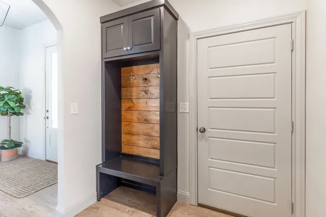a view of a storage and utility room with wooden floor