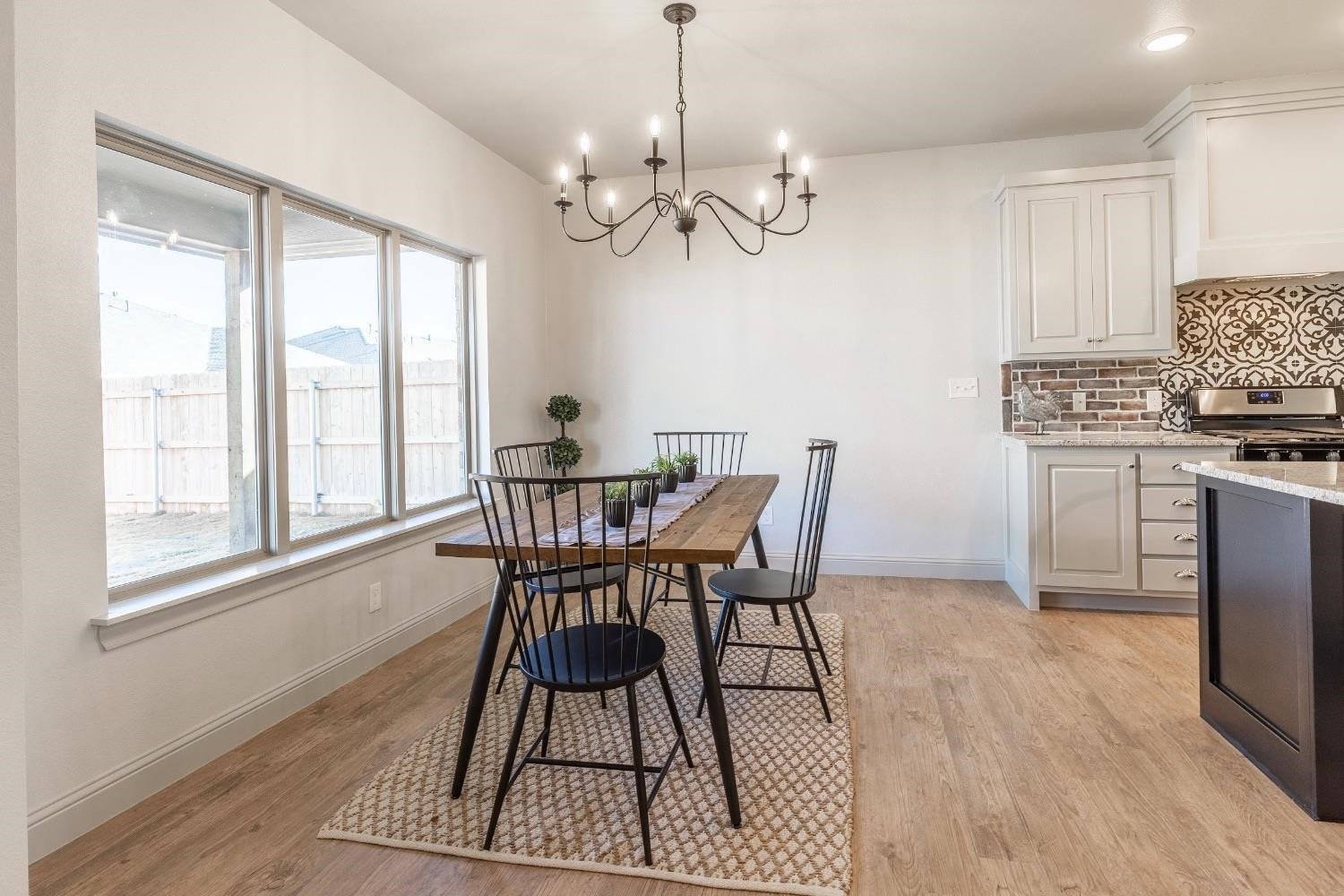 2726 138th Street Lubbock, TX 79423 - Photo 7 of 18 a dining room with wooden floor a chandelier a wooden table and chairs