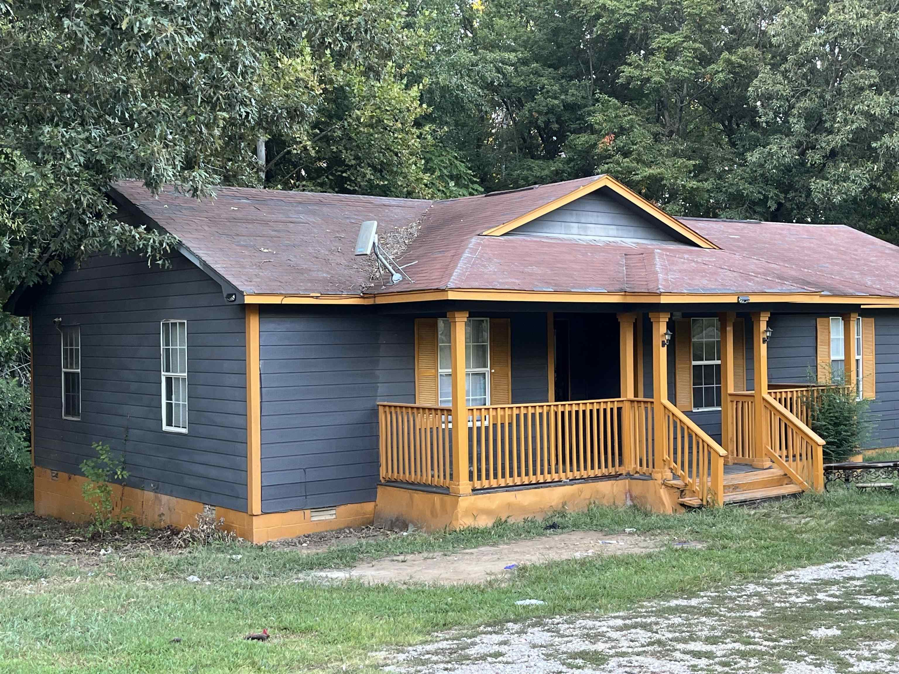 1685 Turner Road Grand Junction, TN 38039 - Photo 1 of 15 Exterior featuring dark siding, a covered front porch with wood railings and columns, white window frames, and a dark shingle roof