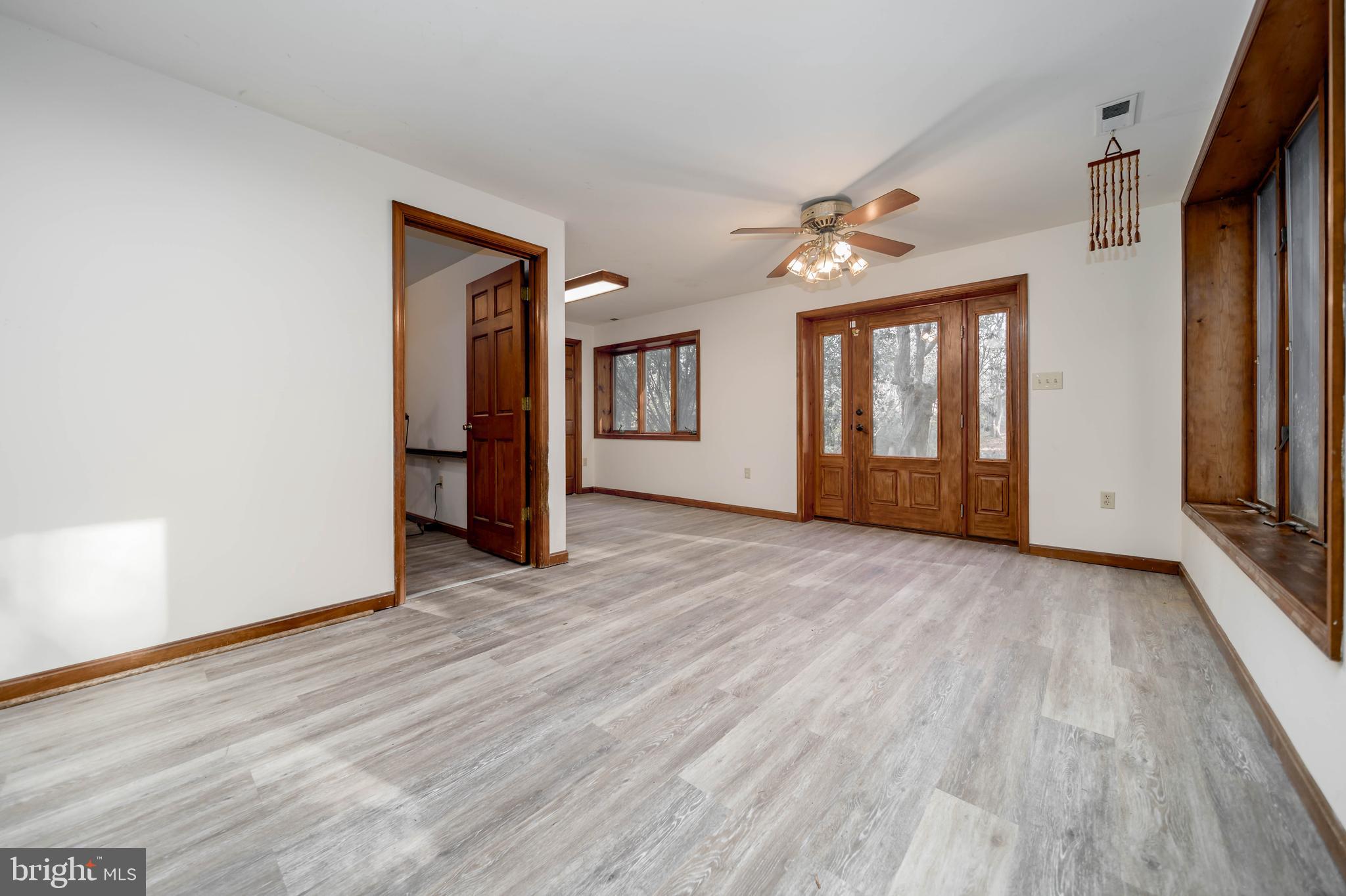 5510 Stephen Reid Road Huntingtown, MD 20639 - Photo 3 of 59 an empty room with wooden floor and ceiling fan