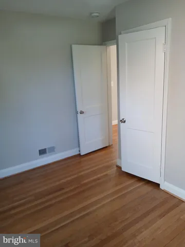 an empty room with wooden floor and closet