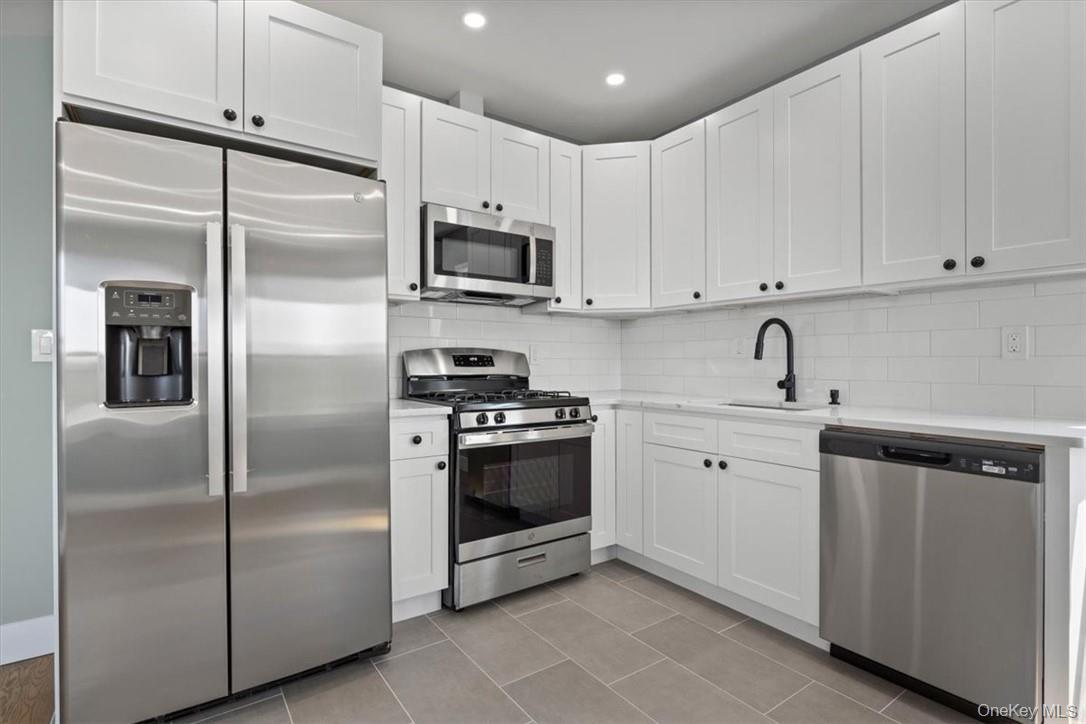 76 Crotona Avenue, Unit 3 Harrison, NY 10528 - Photo 3 of 9 a kitchen with cabinets stainless steel appliances and a counter