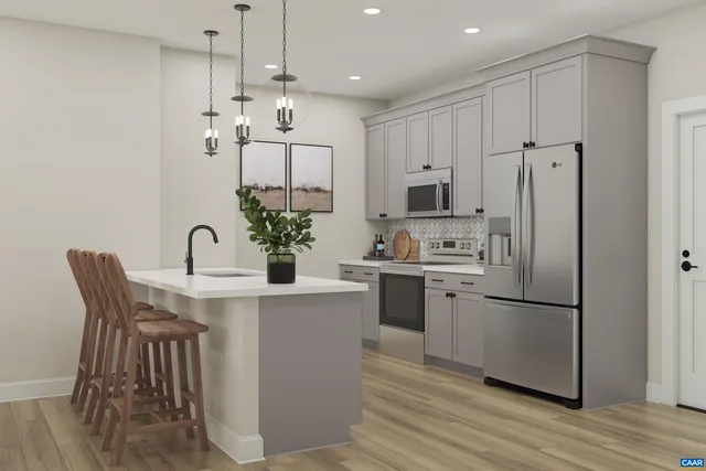 a kitchen with stainless steel appliances kitchen island granite countertop a refrigerator a stove a sink and white cabinets with wooden floor